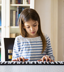 Girl Playing Piano learning how to play keyboard at home